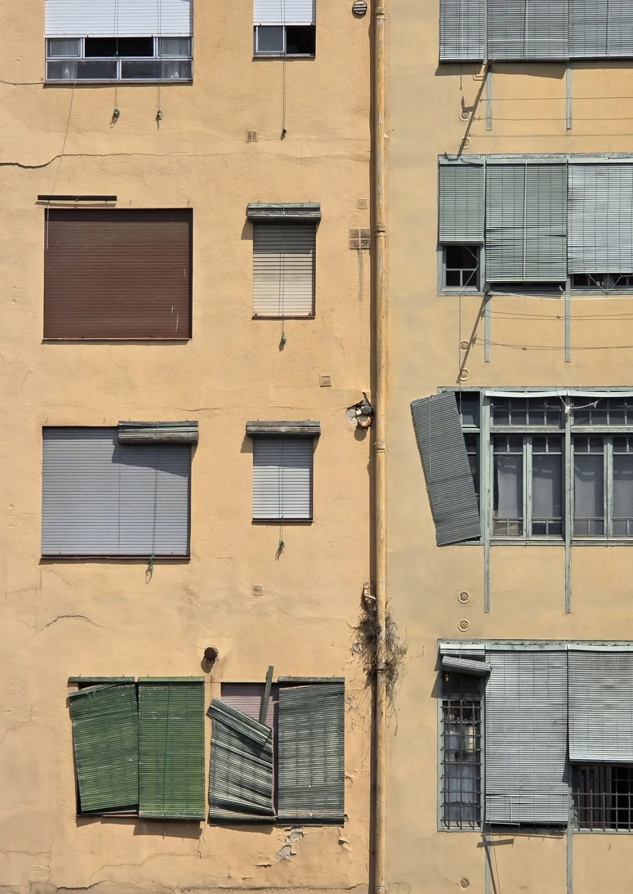 Yellow appartment building with broken window covers