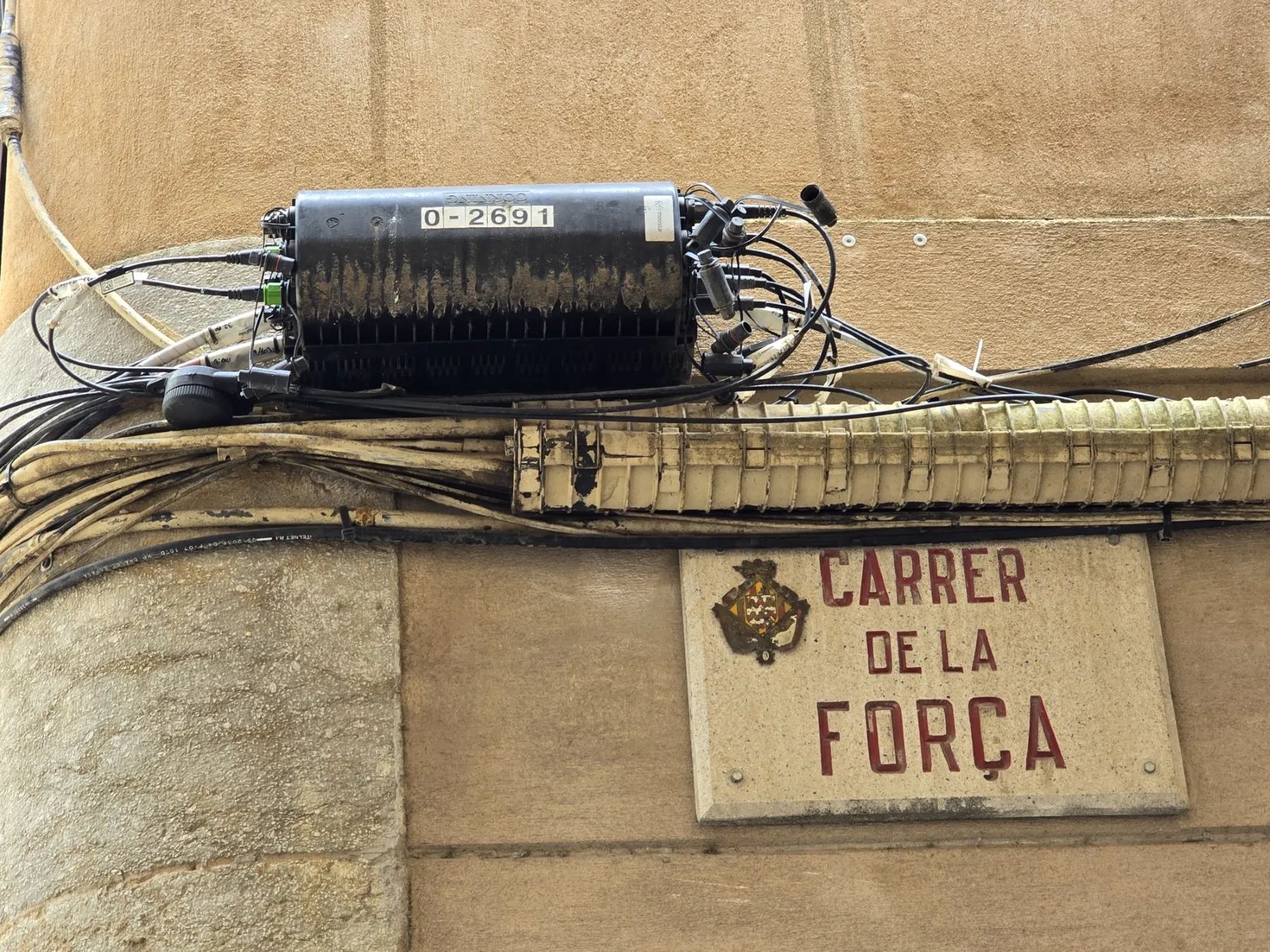 Fiber-optic distribution enclosure mounted to a wall